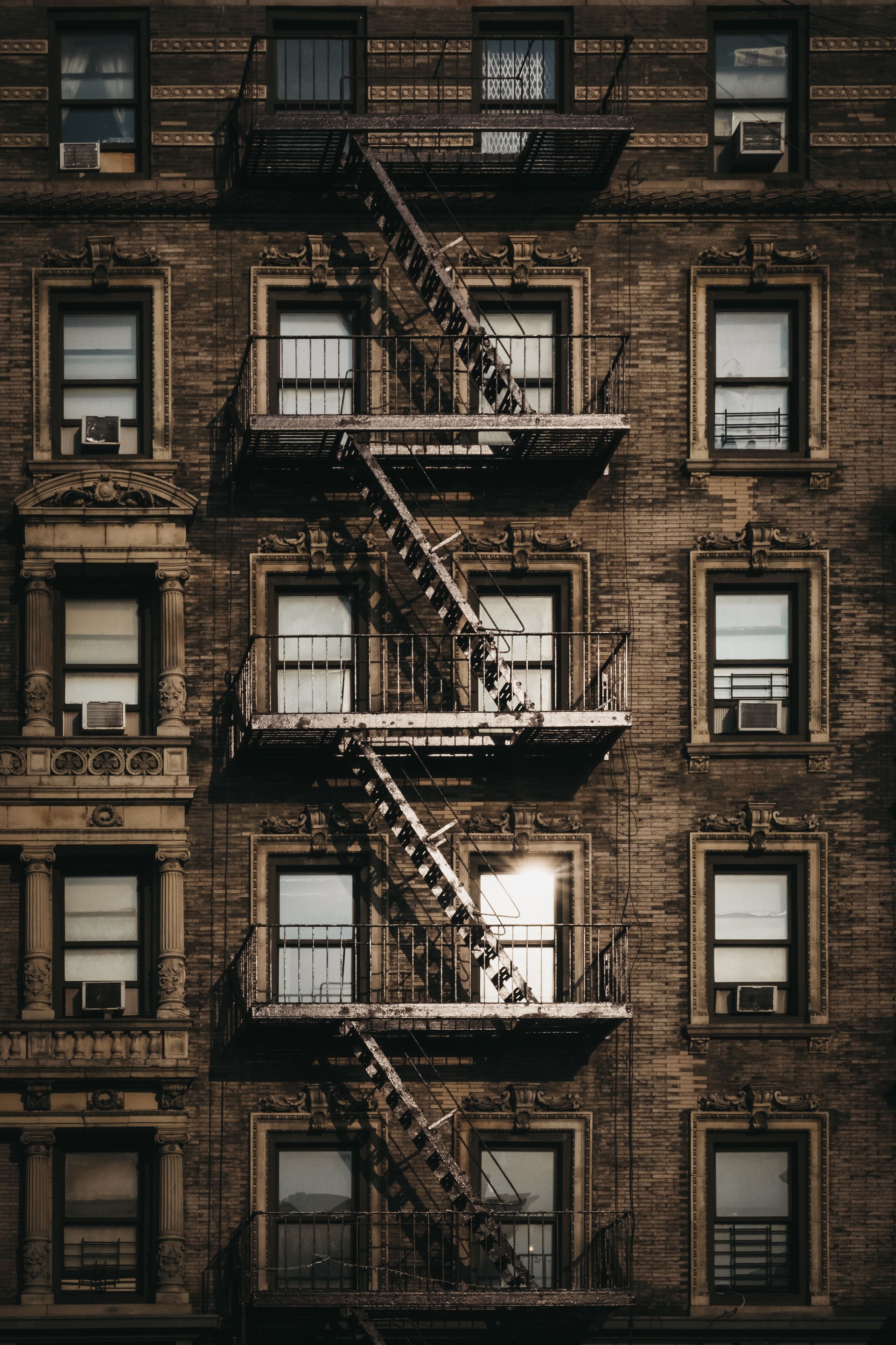Facade of a typical New York block of flats with fire escape at the front.