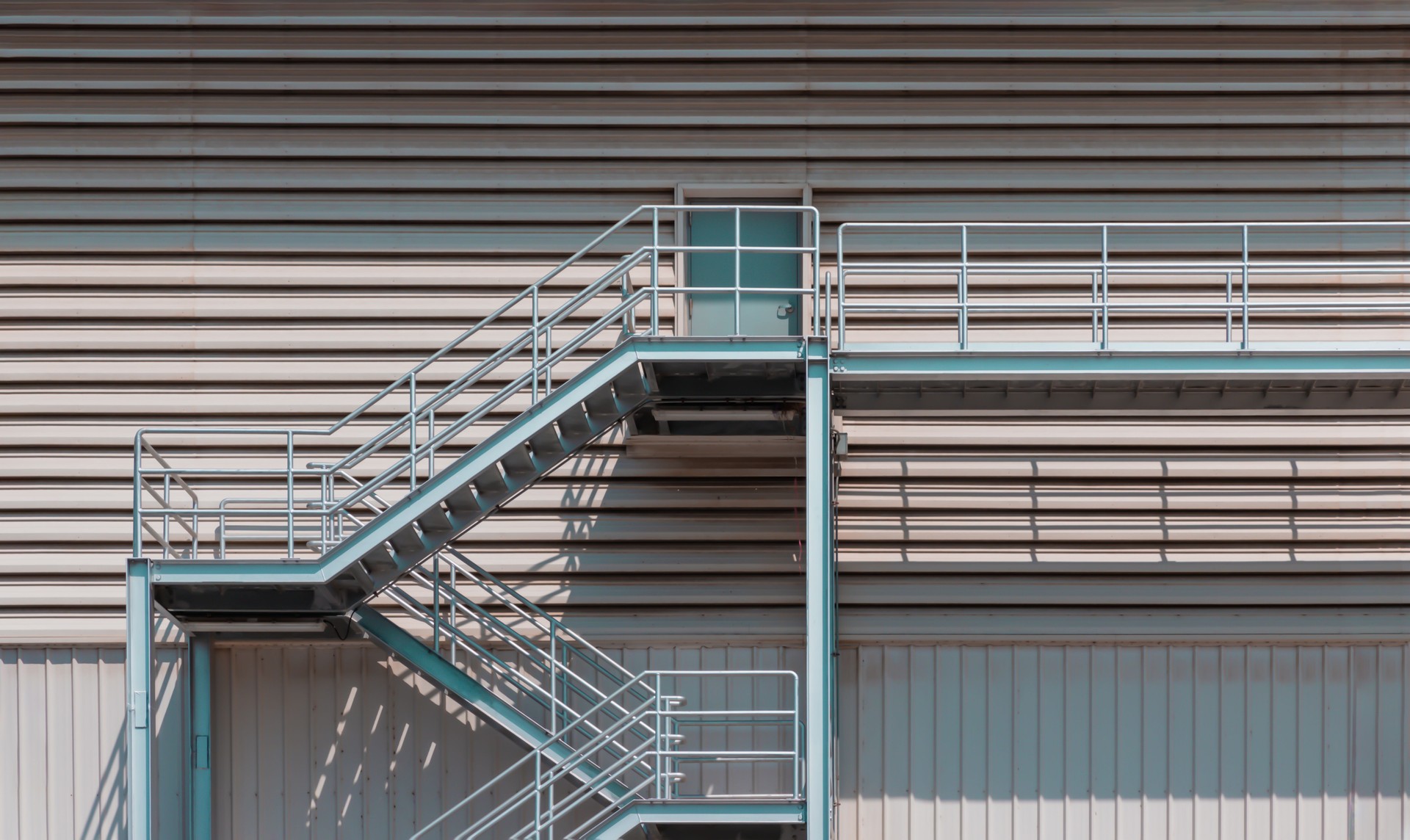 Side view of an external metal staircase as an Fire escape route at modern warehouse building.
