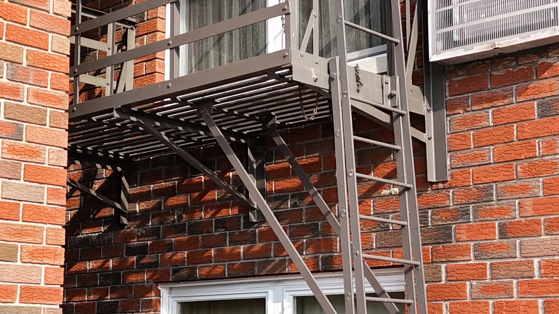 Fire escape platforms and ladder on a brick building